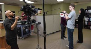 two members of a video production team shooting a corporate video in an office setting